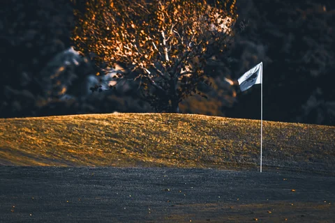 A flag on the green in golden evening light